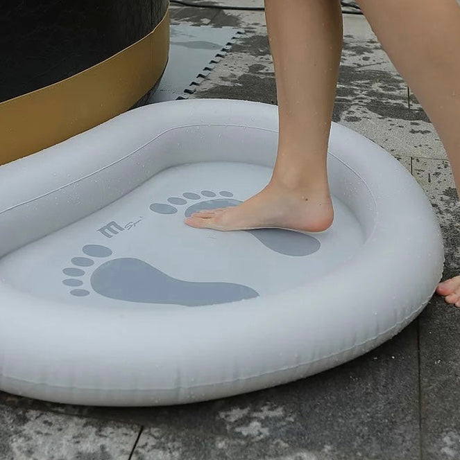 White inflatable foot bath with gray footprint designs, shown with a person's foot inside on a tiled floor. - Home Interior Shop - MSpa Inflatable Pre-Wash Foot Bath