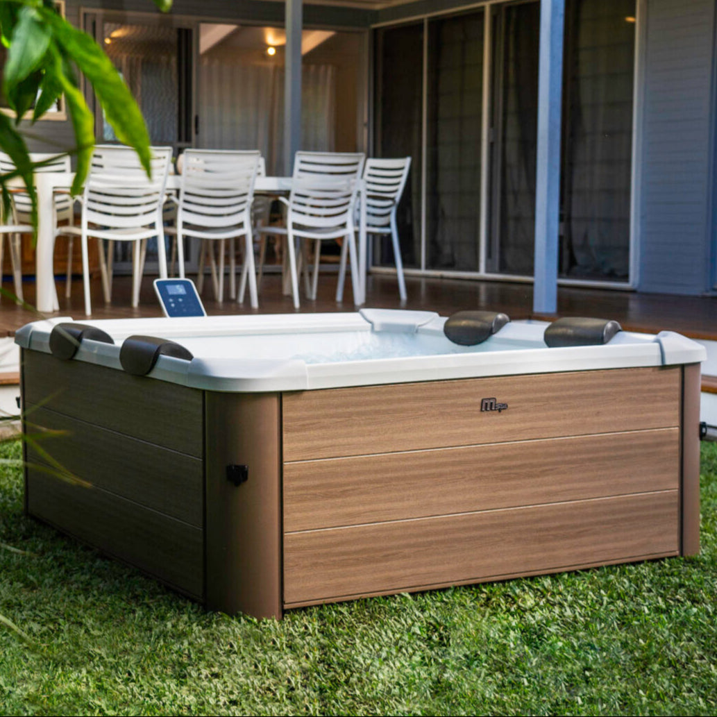 Square portable hard frame hot tub with amber wood-effect panels and white interior, set on grass outdoors with three black. - Home Interior Shop - MSpa Oslo 4-6 Person Portable Hard Frame Hot Tub - Amber