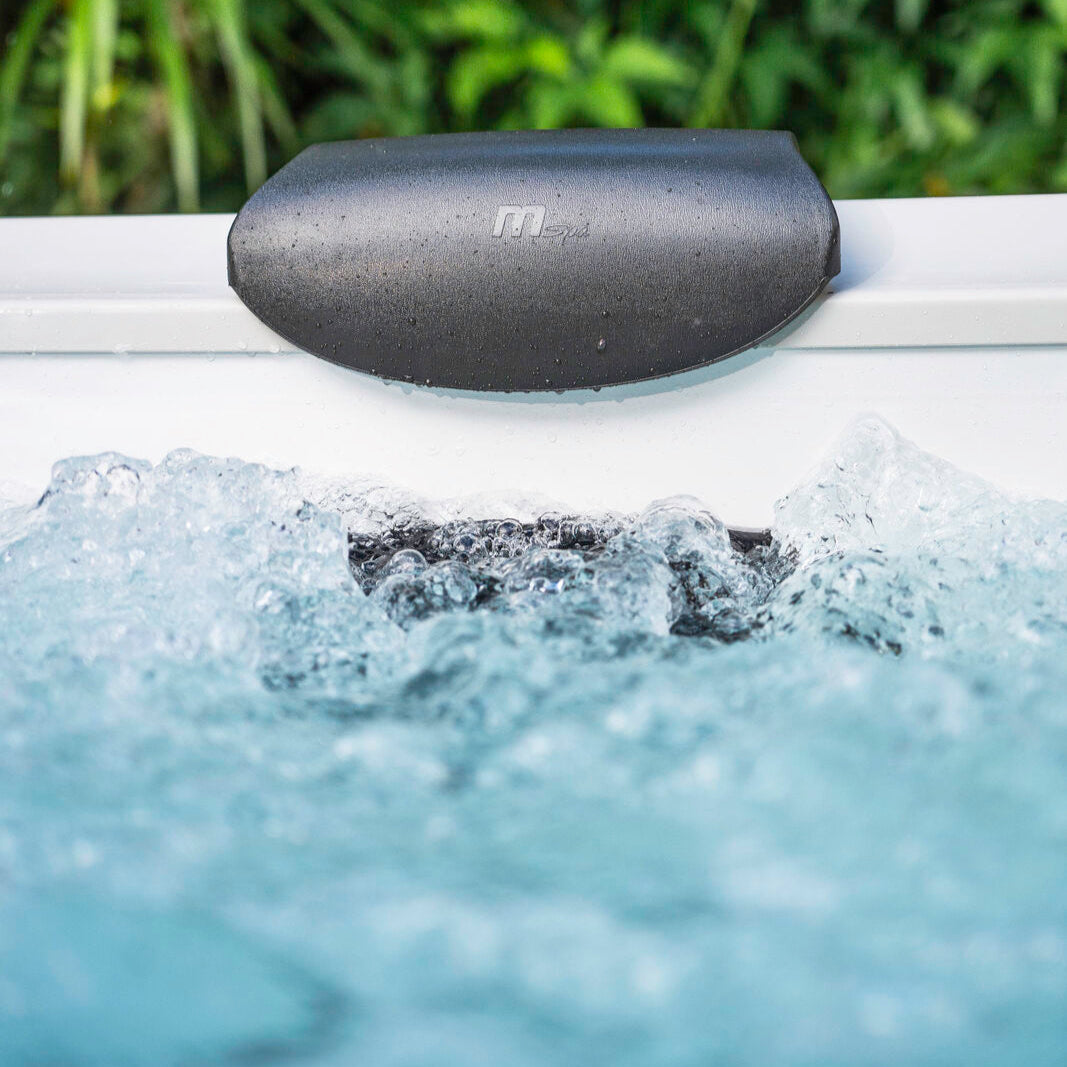 Close-up of bubbling water in amber portable hard frame hot tub with black cushioned headrest and green foliage background. - Home Interior Shop - MSpa Oslo 4-6 Person Portable Hard Frame Hot Tub - Amber