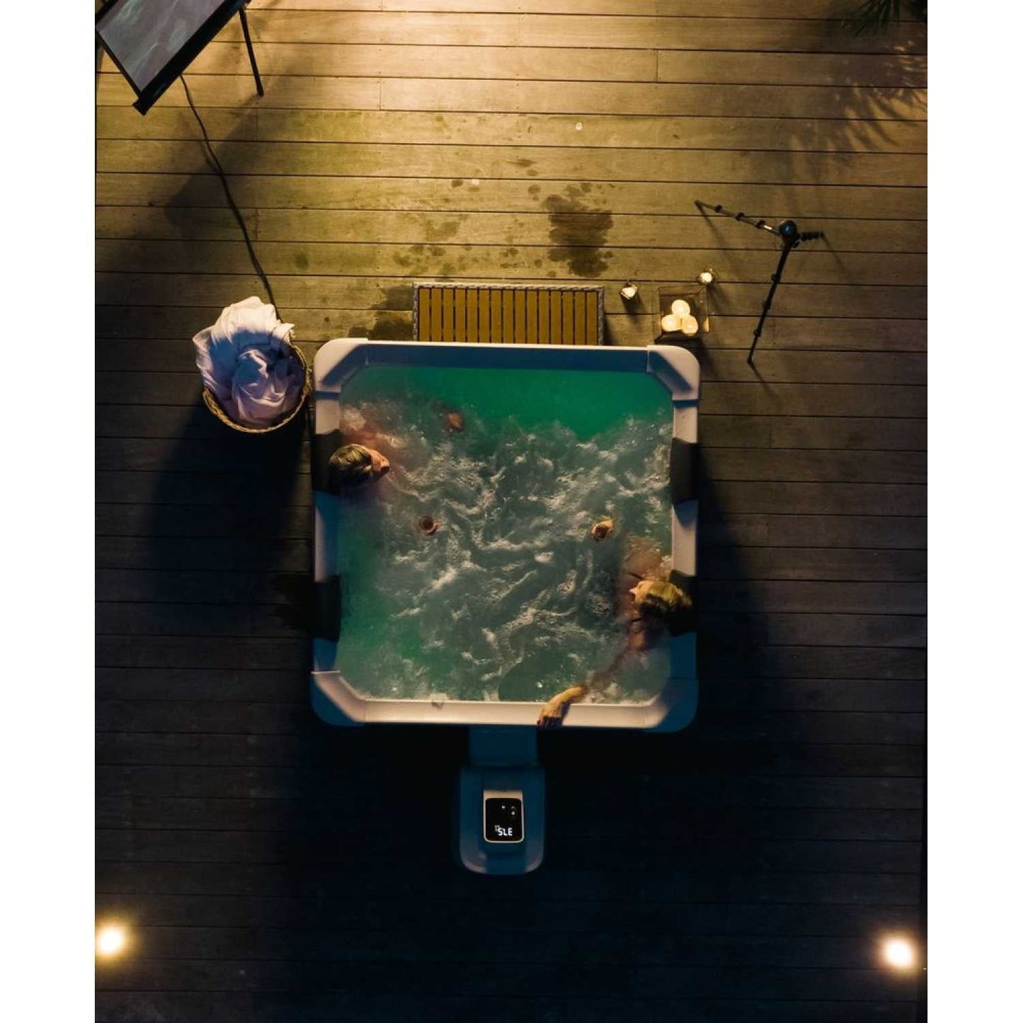 Square grey MSpa Oslo hard frame hot tub with bubbling water and two people relaxing inside on a wooden deck at night with. - Home Interior Shop - MSpa Oslo 4-6 Person Portable Hard Frame Hot Tub - Grey