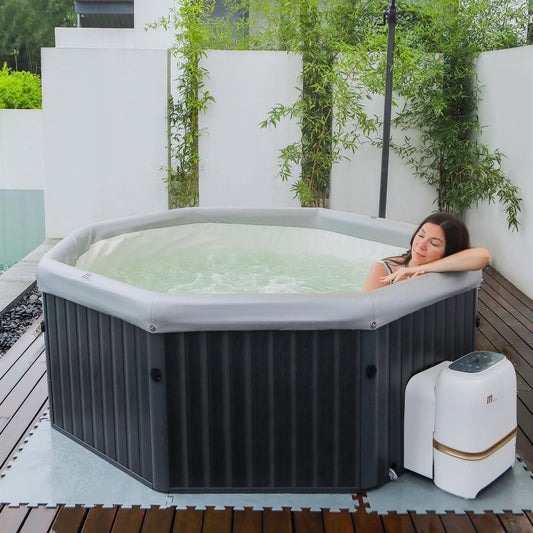 Octagonal black portable hot tub with white interior filled with water on deck, woman relaxing inside, control unit beside. - Home Interior Shop - MSpa Tuscany 4-6 Person Portable Hard Frame Hot Tub